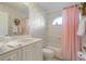 Bathroom with floral wallpaper, a single vanity, a bathtub, and pink shower curtain at 385 Pelican Bnd, Placida, FL 33946