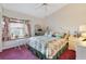 Bedroom with floral bedding, a window seat, pink carpet, and a ceiling fan at 385 Pelican Bnd, Placida, FL 33946