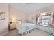 Pink bedroom with a white bed, window seat, and ceiling fan at 385 Pelican Bnd, Placida, FL 33946
