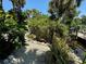 Lush tropical landscaping, a gravel pathway, and a tranquil waterfront view at 4656 Pompano St, Placida, FL 33946
