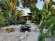 Serene backyard with fire pit, lush landscaping and seating area at 4656 Pompano St, Placida, FL 33946