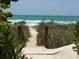 Private beach access path leads to the sandy shore and ocean at 4656 Pompano St, Placida, FL 33946