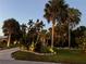 Landscaped front yard with tropical plants and walkway lighting at 4656 Pompano St, Placida, FL 33946