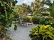 Relaxing patio area with wooden chairs, surrounded by tropical plants at 4656 Pompano St, Placida, FL 33946