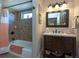 Bathroom with shower/tub combo, tiled walls, single vanity, and decorative mirror at 47 Sportsman Ln, Rotonda West, FL 33947