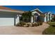 Single story home with light blue exterior, palm trees, and landscaped beds at 47 Sportsman Ln, Rotonda West, FL 33947