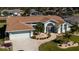 Light blue single-story home with attached two-car garage and landscaped gardens at 47 Sportsman Ln, Rotonda West, FL 33947