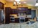 Kitchen features dark wood cabinetry, granite countertops, and stainless steel appliances at 47 Sportsman Ln, Rotonda West, FL 33947