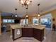 Open-concept kitchen with granite countertops, dark wood cabinets, and view to living area and patio at 47 Sportsman Ln, Rotonda West, FL 33947