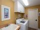 Laundry room with white cabinets, washer, dryer, and utility sink at 47 Sportsman Ln, Rotonda West, FL 33947