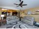 Living room with two grey couches, ceiling fan, and view of the kitchen at 47 Sportsman Ln, Rotonda West, FL 33947
