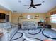 Living room with two gray couches, ceiling fan, and decorative shelving on gold walls at 47 Sportsman Ln, Rotonda West, FL 33947