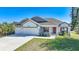 Two-story house with attached two-car garage, red door, and landscaping at 521 W Tarpon Nw Blvd, Port Charlotte, FL 33952