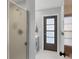 Modern bathroom with gray vanity, updated fixtures, and a frosted glass door at 560 Sandlor Dr, Englewood, FL 34223