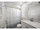 Bathroom with a shower/tub combo, bright white cabinets and grey countertops, and a large mirror at 560 Sandlor Dr, Englewood, FL 34223