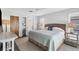 Bright bedroom featuring a woven headboard, ceiling fan, and an adjacent closet and bathroom at 560 Sandlor Dr, Englewood, FL 34223