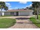 Well-maintained home featuring a manicured lawn, a circular driveway and a two-car garage at 560 Sandlor Dr, Englewood, FL 34223
