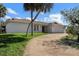 Well-maintained home featuring a manicured lawn, a circular driveway and a two-car garage at 560 Sandlor Dr, Englewood, FL 34223