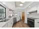 Kitchen with stainless appliances and white cabinets, seamlessly connected to other living areas at 560 Sandlor Dr, Englewood, FL 34223
