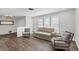 Living room with wood-look floors, two armchairs, and a sofa at 560 Sandlor Dr, Englewood, FL 34223