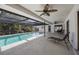 Screened-in pool area with multiple seating areas and ceiling fans for comfortable outdoor living at 560 Sandlor Dr, Englewood, FL 34223