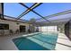 Relaxing screened pool area with clear water, patio seating and bright natural light streaming in at 560 Sandlor Dr, Englewood, FL 34223