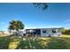 Gray mobile home with attached shed and a large yard at 6375 Partridge Ave, Englewood, FL 34224