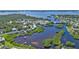 Aerial perspective of the neighborhood with waterway, lush trees, and docks at 7064 Baypine Ln, Englewood, FL 34224