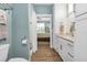 Spacious bathroom featuring white cabinetry, wood-look flooring, and a view to the bedroom at 7064 Baypine Ln, Englewood, FL 34224