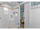 Modern bathroom with glass shower, pebble tile floor, and sliding barn door at 7064 Baypine Ln, Englewood, FL 34224