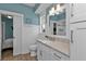 Bathroom with white vanity, wood-look floor, and sliding barn door to the shower at 7064 Baypine Ln, Englewood, FL 34224