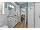 White bathroom with wood-look floors, vanity, and glass enclosed shower at 7064 Baypine Ln, Englewood, FL 34224
