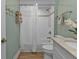 Updated bathroom with white vanity, textured shower tile, and wood-look flooring at 7064 Baypine Ln, Englewood, FL 34224