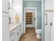 White bathroom vanity with light wood-look floors and built-in shelving for linens at 7064 Baypine Ln, Englewood, FL 34224
