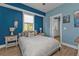 Serene bedroom with blue walls, cozy bed, and a view of the adjacent bathroom at 7064 Baypine Ln, Englewood, FL 34224