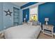 Relaxing bedroom with blue accent wall, comfortable bed, and beach-inspired decor at 7064 Baypine Ln, Englewood, FL 34224