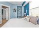 Coastal-themed bedroom with blue accent wall, white bedding, and beachy decor at 7064 Baypine Ln, Englewood, FL 34224