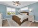 Light blue bedroom with a wicker bed and ceiling fan at 7064 Baypine Ln, Englewood, FL 34224