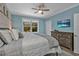 Inviting bedroom with wood plank accent wall, ceiling fan, and large window with natural light at 7064 Baypine Ln, Englewood, FL 34224