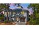Charming two-story home with a metal roof, inviting front porch, and a wooden garage door at dusk at 7064 Baypine Ln, Englewood, FL 34224