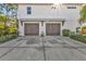 Two-car garage with a clean driveway and landscaping at 7064 Baypine Ln, Englewood, FL 34224