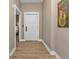 Hallway with wood-look flooring and a view into an adjacent bedroom at 7064 Baypine Ln, Englewood, FL 34224