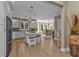 Open kitchen and dining area with white cabinetry, an island with seating, and wood-look flooring at 7064 Baypine Ln, Englewood, FL 34224