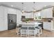 Bright white kitchen featuring an island with seating, stainless steel appliances, and ample counter space at 7064 Baypine Ln, Englewood, FL 34224