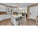 Modern kitchen with white cabinets, a large island, stainless steel appliances, and an adjacent dining area at 7064 Baypine Ln, Englewood, FL 34224