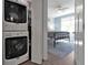 Laundry room with stacked washer and dryer, leading to a bedroom at 7064 Baypine Ln, Englewood, FL 34224