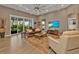 Living room with wood floors, ceiling fan, and access to a balcony at 7064 Baypine Ln, Englewood, FL 34224