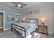 Coastal-themed bedroom with decorative accent wall, ceiling fan, and metal bed frame at 7064 Baypine Ln, Englewood, FL 34224