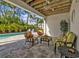 Covered patio with seating area overlooking the pool at 7064 Baypine Ln, Englewood, FL 34224