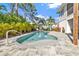 Inviting pool with paved patio, lush landscaping, and a seating area at 7064 Baypine Ln, Englewood, FL 34224